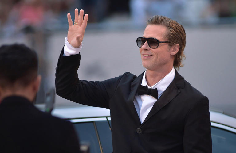 Who is Brad Pitt dating now - A smiling Brad Pitt, dressed in a black tuxedo and sunglasses.